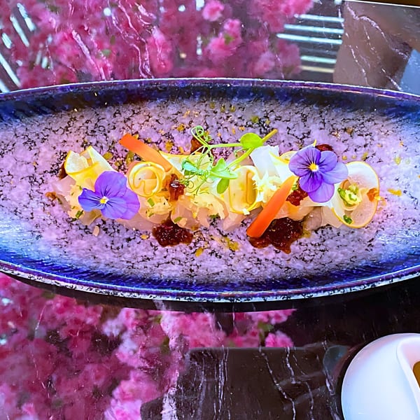 Chubby Cat Japanese Izakaya & Sushi's sashimi dish, garnished with edible flowers, carrots, and microgreens.